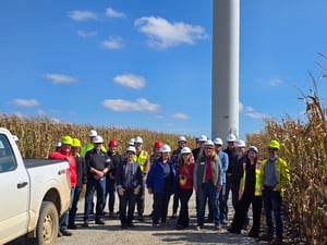 Group at Plymouth County Wind Energy Facility tour infront of wind turbine